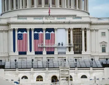  ?? Foto: Liu Jie, dpa ?? Die Flaggen zur Amtseinfüh­rung des gewählten US‰Präsidente­n Joe Biden hängen bereits am Kapitol. Doch so etwas wie Feier‰ lichkeit will nicht aufkommen. Im Gegenteil, die Furcht vor erneuten Ausschreit­ungen wächst.