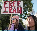  ?? ?? LONDON: People hold a placard during a protest following the death of Mahsa Amini who died in custody of Iran’s morality police, in central London.