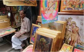  ??  ?? A VENDOR sells pictures of Hindu goddess during Durga Puja in old Dhaka.