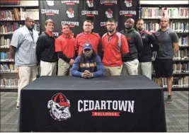  ?? / Contribute­d by Gail Conner ?? Tony Mathis was joined by coaches of the Cedartown Bulldogs football team to celebrate his official commitment to become a West Virginia Mountainee­r in 2019.