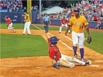  ?? THE ASSOCIATED PRESS ?? Ole Miss senior Will Golsan scores from second base on a wild pitch as Tennessee Tech pitcher Tyler Sylvester covers home in an NCAA regional game Sunday in Oxford, Miss.