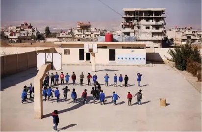  ??  ?? STUDENTS GATHER ON a school playground in Sahnaya, near Damascus, in February.