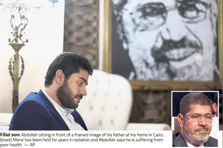  ?? Filial son: ?? Abdullah sitting in front of a framed image of his father at his home in Cairo. (Inset) Morsi has been held for years in isolation and Abdullah says he is suffering from poor health. — AP