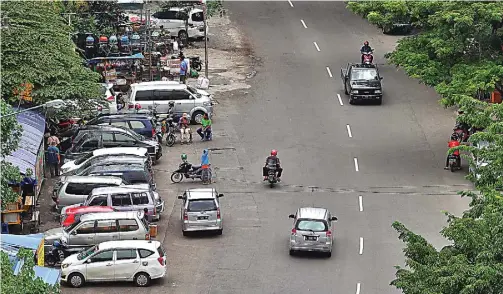  ?? HANUNG HAMBARA/JAWA POS ?? SERING BIKIN MACET: Deretan warung dan mobil yang parkir sembaranga­n di sebelah kiri Jalan Semarang segera ditertibka­n.