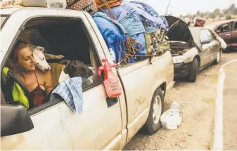  ?? Stephen Lam / The Chronicle ?? Regina Rutledge fled her Plumas County home with her dogs and sits in her truck at a shelter.