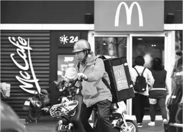  ??  ?? A food delivery man leaving a McDonald’s restaurant in Beijing. US President Donald Trump’s tariffs on Chinese goods have roused some nationalis­t sentiment in the world’s second largest economy, where consumers have a long track record of spurning...