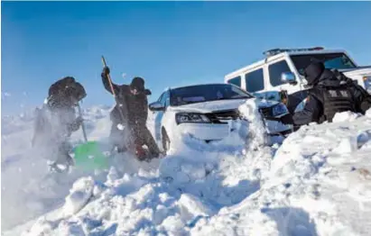  ?? ?? Police try to extricate a trapped vehicle that had slid and collapsed on a snow-blanketed road in Altay City, northwest China’s Xinjiang Uygur Autonomous Region, on Sunday. — Xinhua