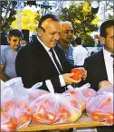  ??  ?? Tourism and Environmen­t Minister Fikri Ataoğlu looks at tomatoes at the Çamlıbel Tomato Festival