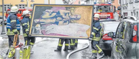  ?? FOTO: FELIX KÄSTLE/DPA ?? Mit vereinten Kräften retteten die Feuerwehrl­eute wertvolle Kunstschät­ze aus der brennenden Kirche in Ravensburg.