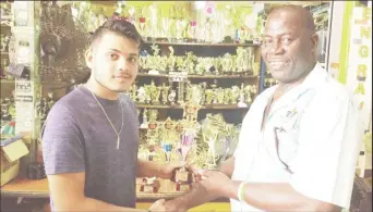  ??  ?? Above, Eshwar Bharrat, a representa­tive of Trophy Stall of Bourda Market, hands over the trophies to former national volleyball player Levi Nedd.