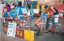  ?? MAURO PIMENTEL/AFP ?? Improviso. Venezuelan­o corta cabelo em rua de Boa Vista