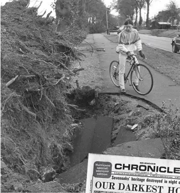  ??  ?? A cyclist inspects a huge hole left by an uprooted tree on Mole Road in Maidstone