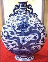  ??  ?? A picture shows a rare blue, white and celadon porcelain moon flask with a dragon which belonged to the 18th century’s emperor Qianlong. — AFP photos