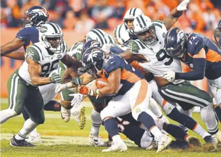  ??  ?? Broncos running back C.J. Anderson gives the Jets’ defense a workout Sunday at Sports Authority Field.