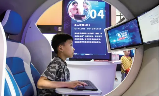  ??  ?? A child tries an online education product at the Sixth Popular Science Products Expo in Shanghai on August 23