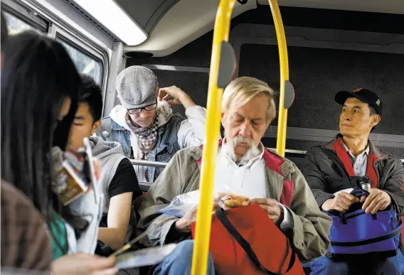  ?? Photos by Mike Kepka / The Chronicle ?? MatthewWal­ker pets his rat Fish while another bus rider keeps an eye on the two. Walker tries not to take the bus because people’s reactions to Fish vary.