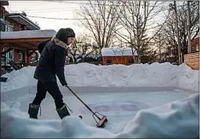  ??  ?? Félix Rhéaume entretient sa patinoire à Montréal, le 10 février.