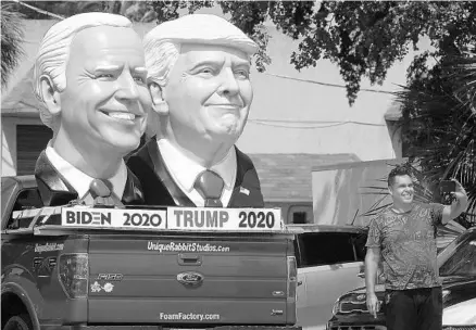  ?? JOE CAVARETTA/SOUTH FLORIDA SUN SENTINEL ?? People have been stopping along Dixie Highway in Fort Lauderdale to take selfies and photos of foam sculpture depictions of President Trump and candidate Joe Biden, as seen Thursday. Biden leads Trump in Florida, according to polls released this week.