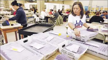  ?? Genaro Molina Los Angeles Times ?? CITY WORKER Amy Milo looks over cartons of uncounted ballots at Piper Technical Center in L.A. Voters approved two ballot measures that will align city political campaigns with state and federal elections.