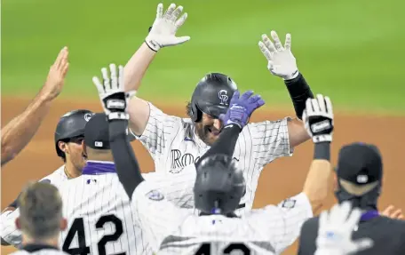  ?? Andy Cross, The Denver Post ?? Rockies pinch hitter, Daniel Murphy, back, celebrates his walk- off single against the San Diego Padres in the ninth inning at Coors Field on Saturday night.