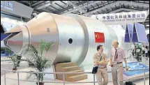  ?? AP FILE ?? Visitors in front of a model of China's Tiangong1 space station at an aviation and aerospace exhibition in Guangdong.