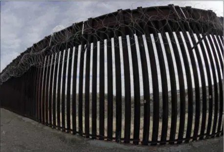  ?? AP PHOTO/CHARLIE RIEDEL ?? A razor-wire-covered border wall separates Mexico, in the distance, and the United States Saturday, March 2, 2019 .