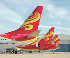  ?? ImagineChi­na ?? Hainan Airlines jets at Haikou Meilan Internatio­nal Airport. The airline’s shares have been suspended for six months