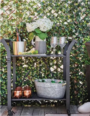  ??  ?? RIGHT The bar cart used to be white. Sandy primed and painted it black with weatherpro­of paint. Her tip? “Use matte paint for outdoors so it won’t reflect the sun.”