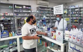  ?? Associated Press ?? Pharmacist Ziad Jomaa sells medicine to a customer in his pharmacy in Bchamoun village outside of Beirut, Lebanon, on Oct. 28.