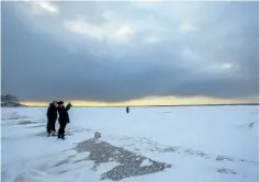  ?? JULIE JOCSAK/ STANDARD STAFF ?? People watch as passing storm clouds give way to a beautiful winter sunset at Lakeside Park Beach in Port Dalhousie. Mother Nature gave Niagara a good dumping of snow on Wednesday, and more is in the weekend forecast.