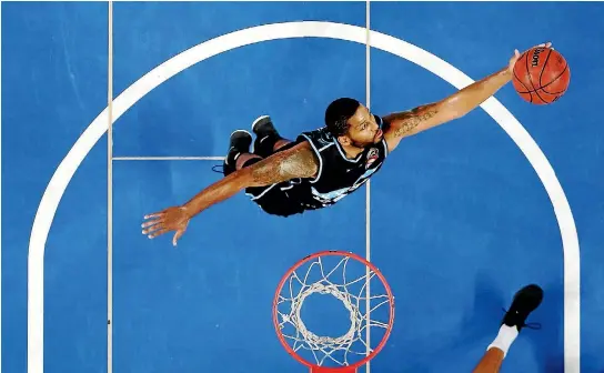  ?? PHOTOS: GETTY IMAGES ?? DJ Newbill of the Breakers grabs a rebound against the Brisbane Bullets in Auckland on Thursday night.