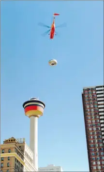  ??  ?? A heavy-lift helicopter carries the Olympic cauldron to the top of the Calgary Tower in November 1987.