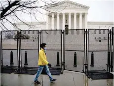  ?? — Reuters ?? A man walks past barbed wire and security fencing surroundin­g the US Supreme Court in Washington.