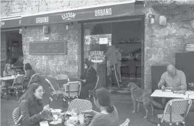  ?? ARIEL SCHALIT/AP ?? Diners eat March 7 at a Tel Aviv restaurant as restrictio­ns are eased after months of shutdowns imposed by Israel.