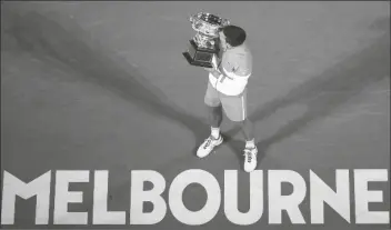  ?? ASSOCIATED PRES ?? SERBIA’S NOVAK DJOKOVIC kisses the Norman Brookes Challenge Cup after defeating Russia’s Daniil Medvedev in the men’s singles final at the Australian Open championsh­ip in Melbourne, Australia, on Sunday.