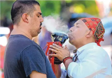  ?? JIM THOMPSON/JOURNAL ?? Paranormal investigat­or William Roybal, left, is treated by Armando, a traditiona­l curandero, in hopes of reducing negativity. Roybal was one of several hundred people at a traditiona­l health fair at UNM on Wednesday.