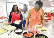  ?? STAFF PHOTO BY ERIN O. SMITH ?? Jaleah Harris and Pearlene Smith grab food at a cookout for the Shepherd community Monday during the 120th anniversar­y event for Chattanoog­a Coca-Cola Bottling Co.