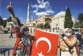  ?? Ozan Kose / AFP via Getty Images ?? People gather outside the Hagia Sophia in Istanbul to celebrate after Turkish President Recep Tayyip Erdogan formally converted the UNESCO World Heritage site into a mosque.