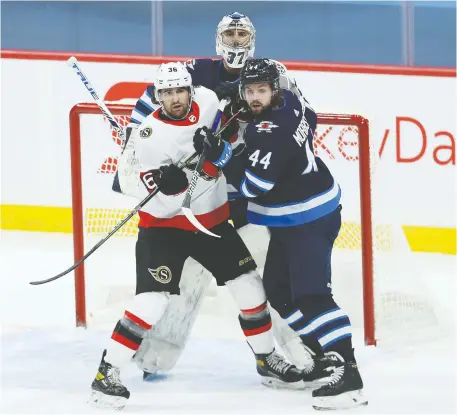  ?? KEVIN KING ?? Ottawa Senators centre Colin White, left, jockeys for position in front of Jets goalie Connor Hellebuyck, with defenceman Josh Morrissey stepping in, on Thursday night in Winnipeg. For Ottawa, having top goaltender Matt Murray out at least temporaril­y is a concern.