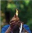  ?? VINCENT THIAN / AP ?? A Indian man prays with lit coconut as an offering outside a temple during Diwali in Kuala Lumpur, Malaysia, Thursday.