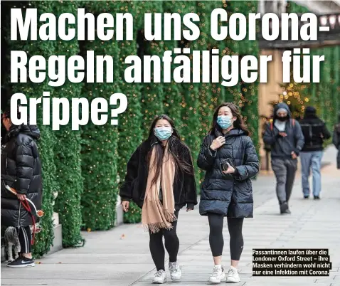  ??  ?? Passantinn­en laufen über die Londoner Oxford Street – ihre Masken verhindern wohl nicht nur eine Infektion mit Corona.