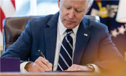  ??  ?? Joe Biden signs the American Rescue Plan in the Oval Office. Photograph: Andrew Harnik/AP