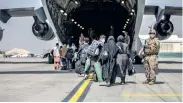  ??  ?? Families begin to board a US Air Force C-17 Globemaste­r III transport plane during an evacuation at Hamid Karzai Internatio­nal Airport, Afghanista­n