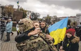  ?? FINBARR O'REILLY NYT ?? A Ukrainian soldier is hugged at the main square in the recently liberated city of Kherson, Ukraine, on Saturday.