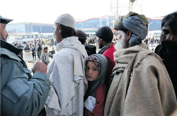  ?? DAVID PUGLIESE PHOTOS ?? Afghans in Kabul line up for food provided by the U.S. government and distribute­d by the French humanitari­an organizati­on Agency for Technical Cooperatio­n and Developmen­t.