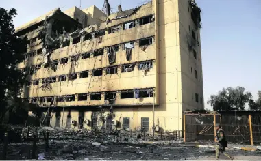  ?? PICTURE: AP ?? CASUALTY: An Iraqi soldier patrols past al-Salam hospital in Mosul, Iraq. The hospital has been left almost completely gutted by the battle to retake the city. It was the scene of a setback for Iraqi troops in the Mosul operation, but was retaken this...