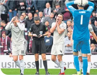  ??  ?? Aberdeen players are frustrated as ref Kevin Clancy awards a first-half penalty