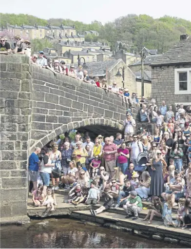  ?? ?? Crowds of people watching the traditiona­l Easter Monday duck race in Hebden Bridge