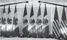  ?? MARCO UGARTE, AP ?? National flags representi­ng Canada, Mexico and the U.S. are lit by stage lights for talks in Mexico City.