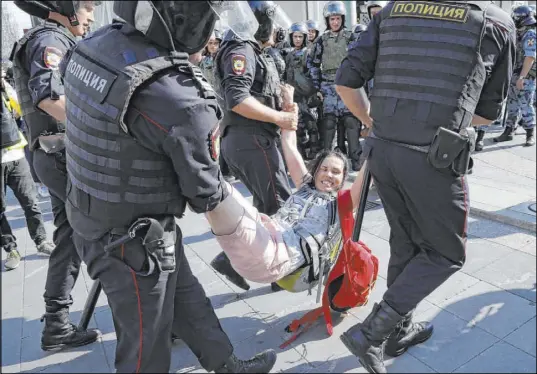  ?? Alexander Zemlianich­enko The Associated Press ?? Police officers detain a woman during an unsanction­ed rally Saturday in Moscow over the exclusion of opposition candidates.